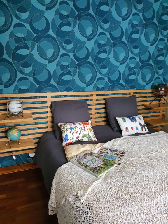 a bedroom with a bed and a blue wall at A l'Ecole Buissonnière, chambre d'hôtes en Sidobre in Lacrouzette