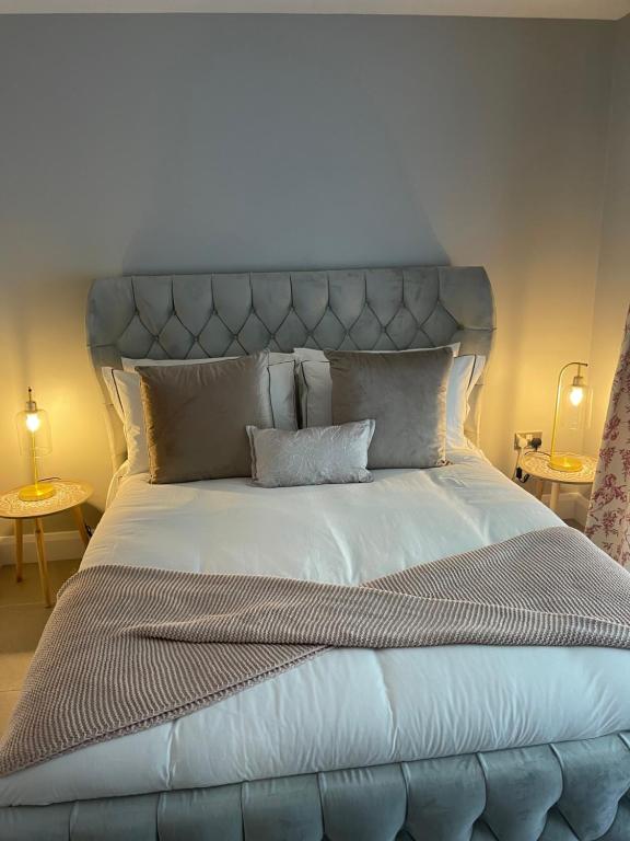 duże łóżko z niebieskim zagłówkiem w sypialni w obiekcie St Elmos Townhouse w mieście Londonderry/Derry
