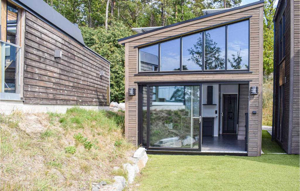 a modern house with glass doors and a yard at Nice Home In Brevik With Kitchen in Bjønnes
