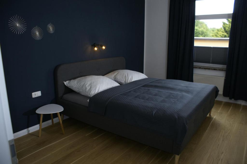 Bett in einem Schlafzimmer mit blauer Wand in der Unterkunft APARTMENT SONNE Reusa in Plauen