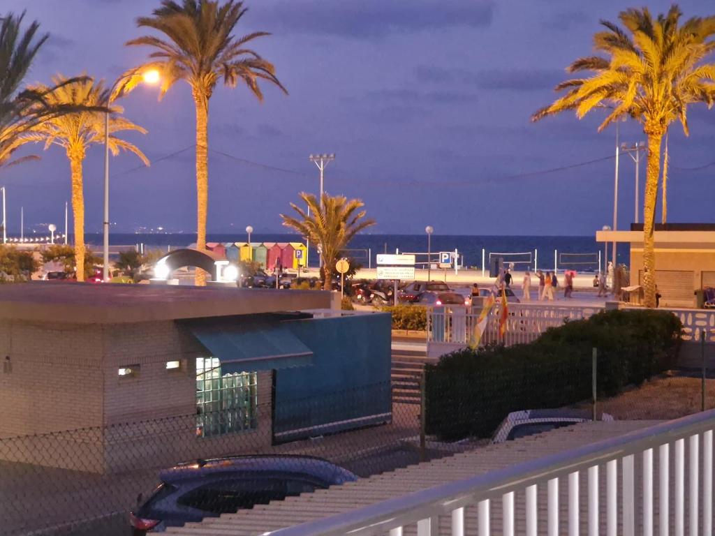 a parking lot with palm trees and the beach at night at Miyas 2, PRIMERA LÍNEA DE PLAYA in Benimagrell