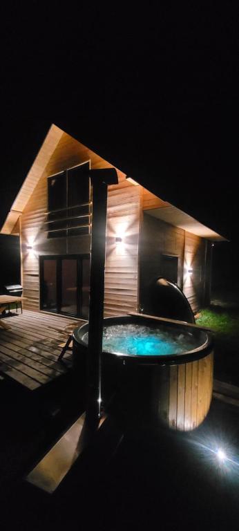 a swimming pool in front of a house at night at Domek drewniany letniskowy całoroczny nad jeziorem 