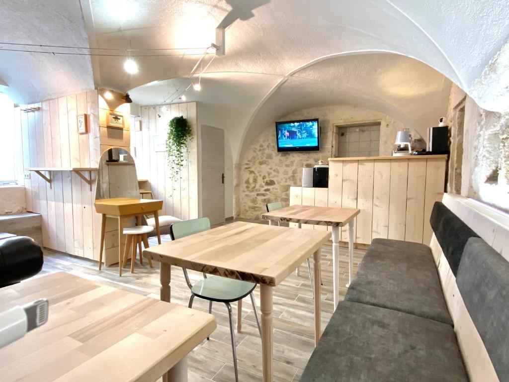 kuchnia i jadalnia z drewnianymi stołami i krzesłami w obiekcie Espace Le Cheval Blanc w mieście Castelnau-le-Lez