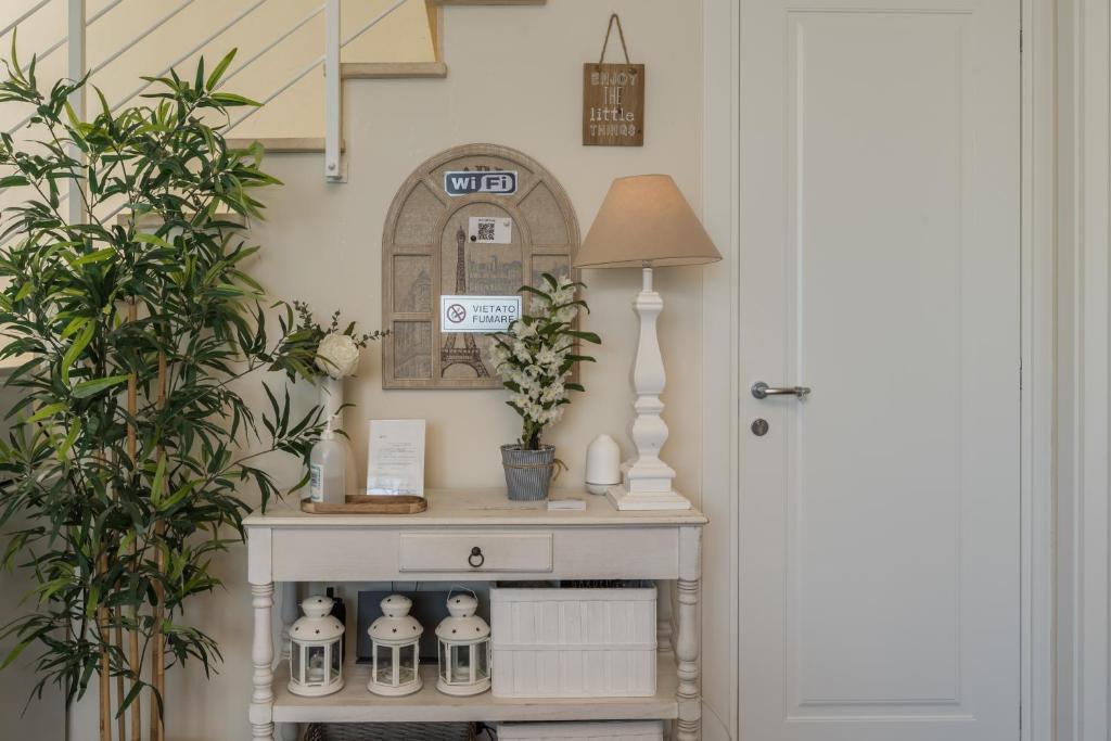 a console table in a hallway with a lamp and plants at B&B L'Ulivo Fiumicino in Fiumicino