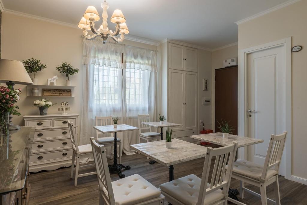 a dining room with tables and chairs and a chandelier at B&B L'Ulivo Fiumicino in Fiumicino