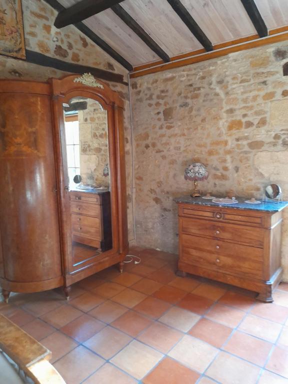 Pokój z drewnianą szafką i lustrem w obiekcie La petite maison bleue avec piscine w mieście Loubejac