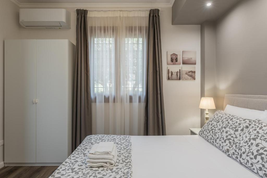 a bedroom with a large white bed and a window at B&B L'Ulivo Fiumicino in Fiumicino