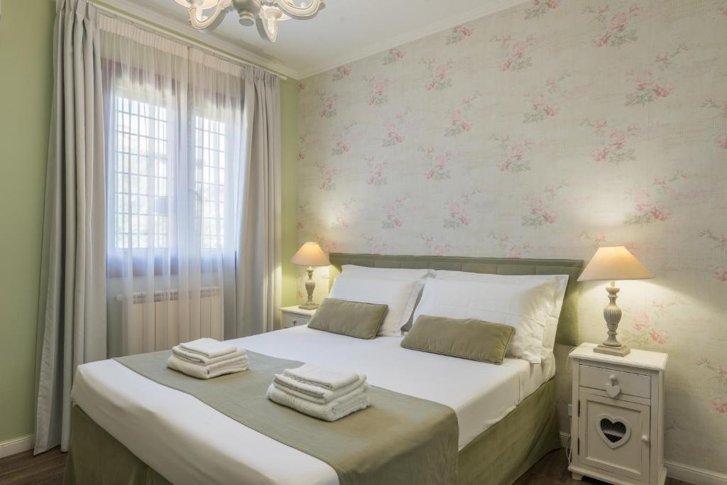 a bedroom with a large bed with pink floral wallpaper at B&B L'Ulivo Fiumicino in Fiumicino