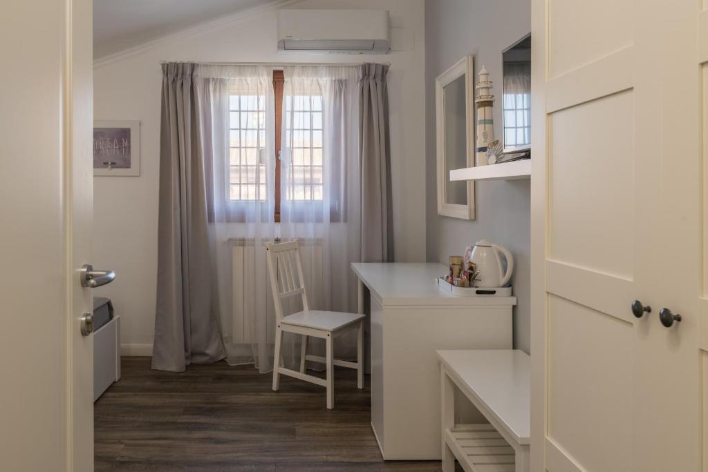 a white kitchen with a table and a chair at B&B L'Ulivo Fiumicino in Fiumicino