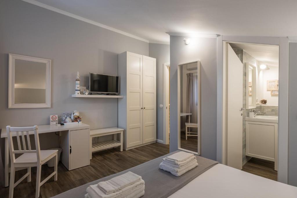 a bedroom with a bed and a desk and a mirror at B&B L'Ulivo Fiumicino in Fiumicino