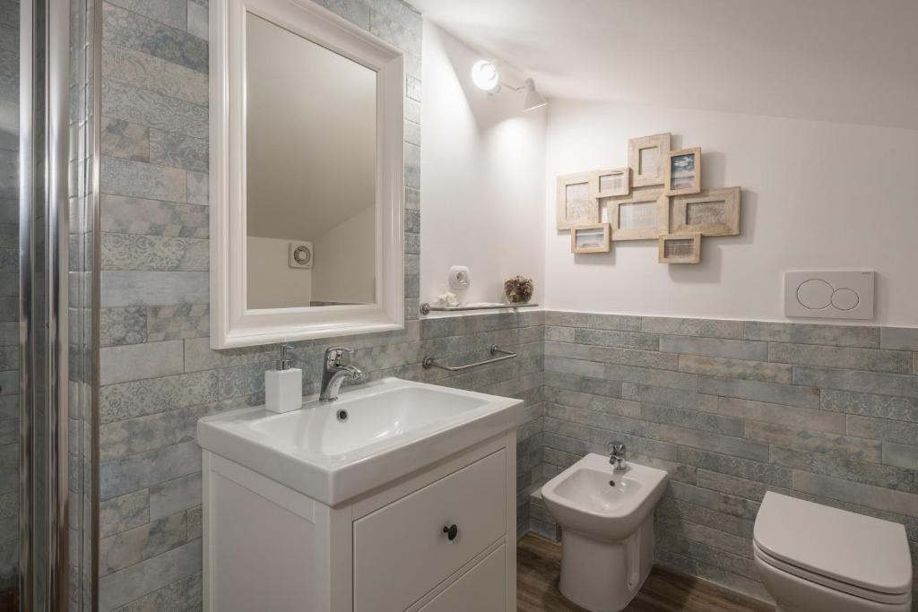 a bathroom with a sink and a toilet and a mirror at B&B L'Ulivo Fiumicino in Fiumicino
