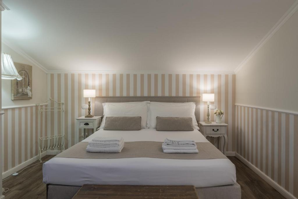 a bedroom with a large bed with two towels on it at B&B L'Ulivo Fiumicino in Fiumicino