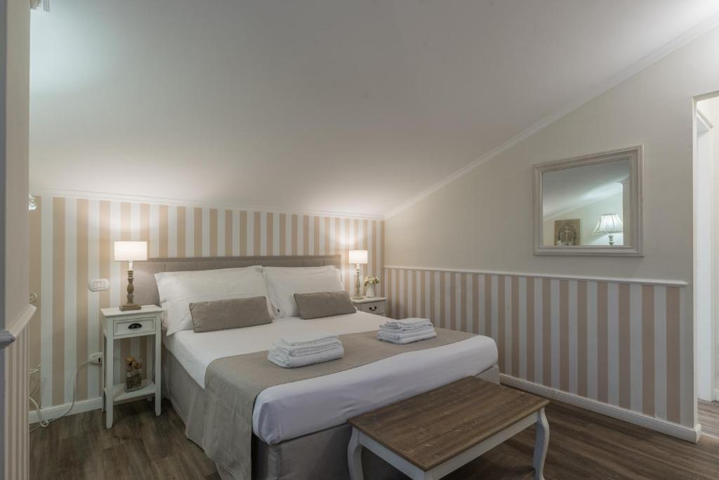 a bedroom with a large bed and a mirror at B&B L'Ulivo Fiumicino in Fiumicino