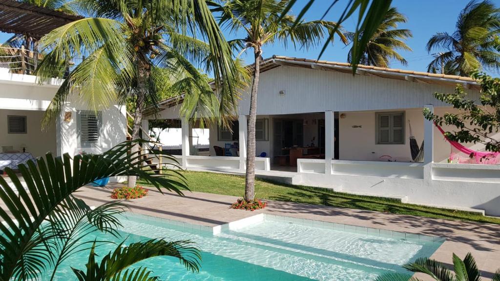 a villa with a swimming pool in front of a house at Vila Yoga - Kitesurf Pontal de Maceió in Fortim
