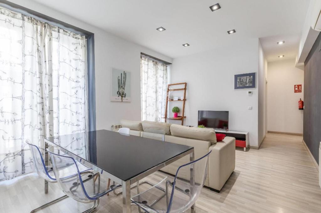 sala de estar con mesa y sofá en Spacious flat puerta del sol, en Madrid