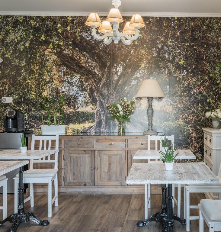 a dining room with a tree mural on the wall at B&B L'Ulivo Fiumicino in Fiumicino
