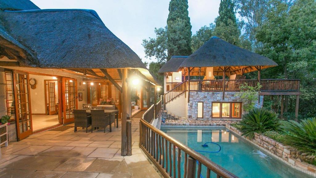 a house with a swimming pool and a building at Malinga GuestHouse in Sandton
