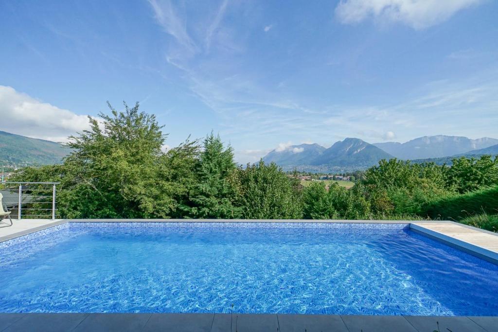 a swimming pool with a view of mountains at La Petite Montagne in Saint-Jorioz