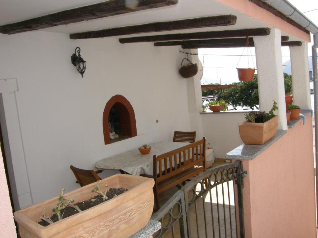 a balcony of a house with a table and a fence at Apartment Haramina in Baška