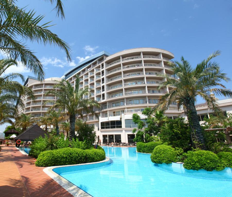 a large hotel with palm trees and a swimming pool at Liberty Hotels Lara in Lara