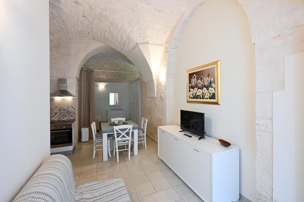 een woonkamer met een bank, een tv en een tafel bij Casa vacanze nonna donata in Martina Franca