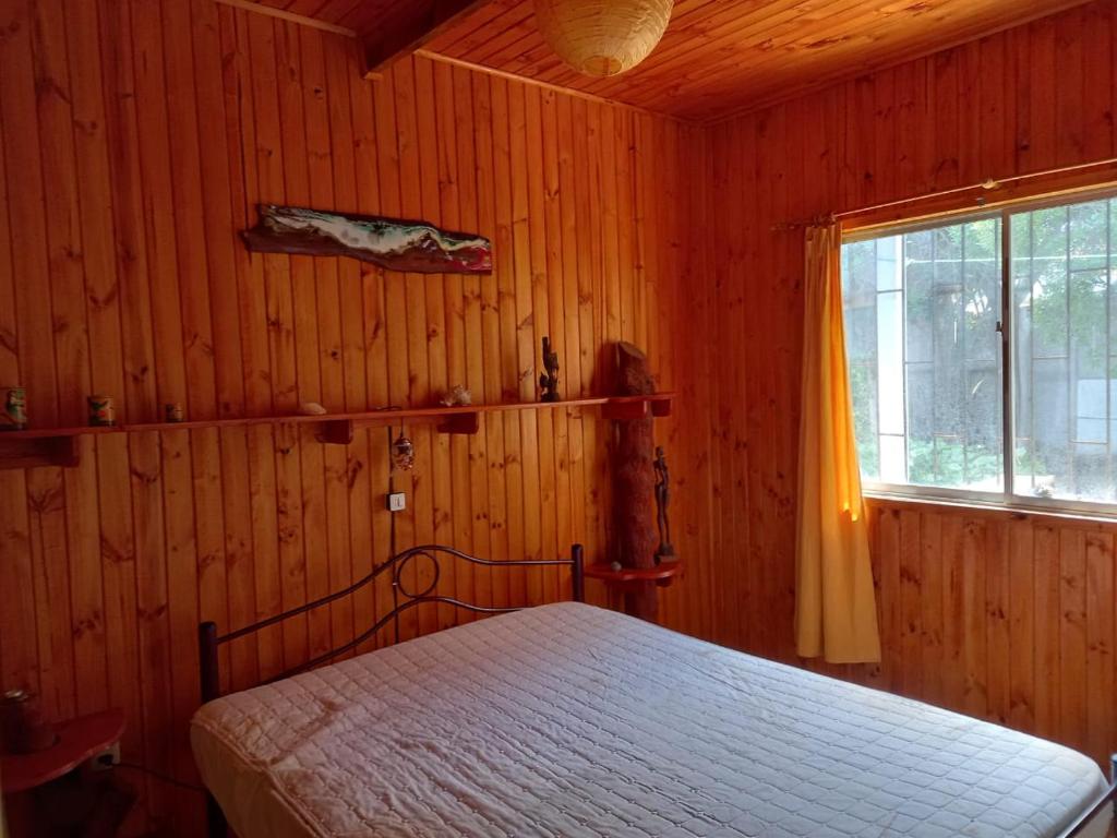 a bedroom with a bed in a wooden room at Frente al Mar entre Poetas in El Tabo