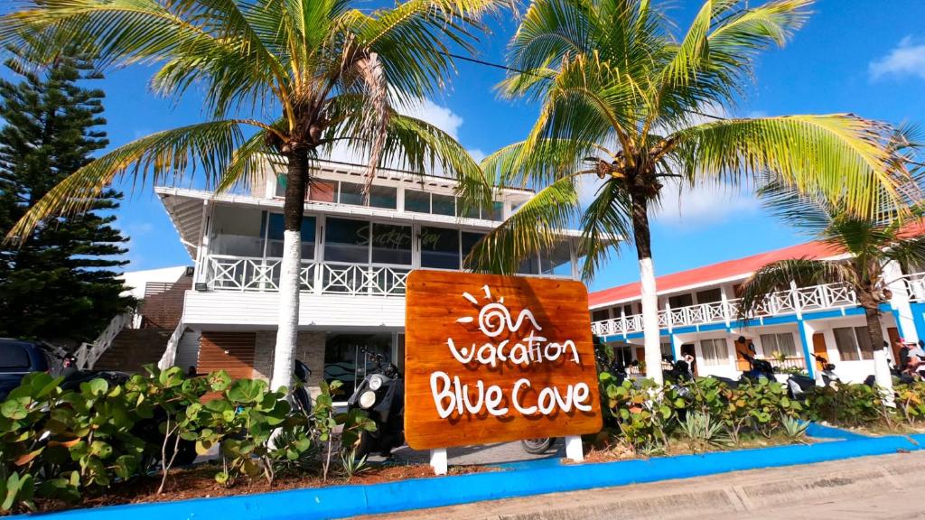 ein Schild vor einem Gebäude mit Palmen in der Unterkunft On Vacation Blue Cove in San Andrés