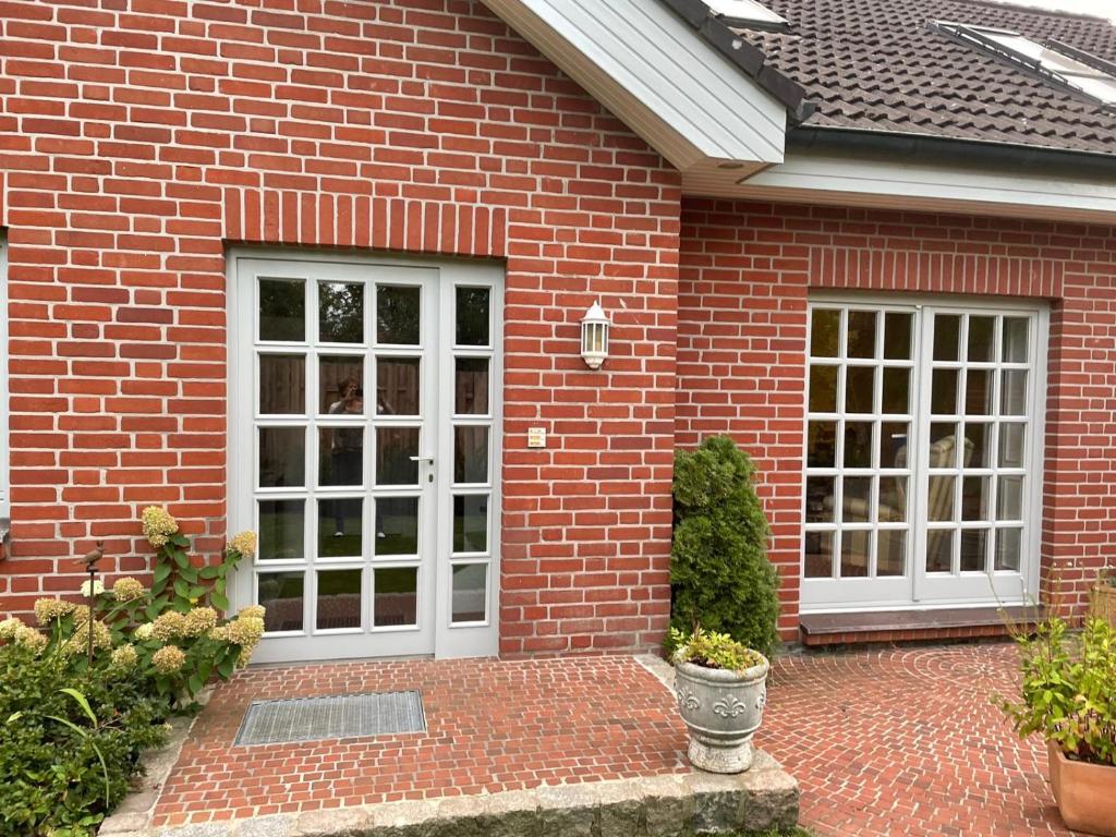 a brick house with white doors and a brick patio at Garden View Apartment in Bad Segeberg