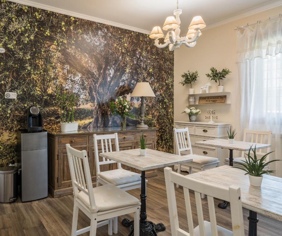 a dining room with tables and chairs and a wall mural at B&B L'Ulivo Fiumicino in Fiumicino