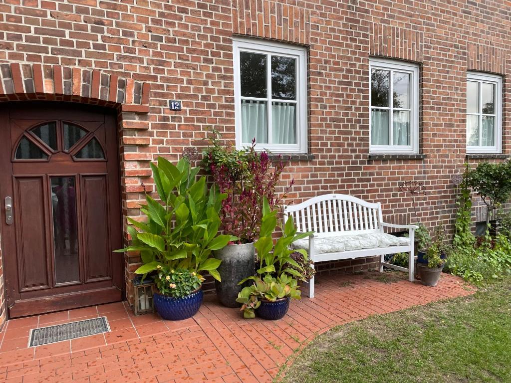 a bench sitting in front of a brick building with plants at große Wohnung zentral gelegen in Neubrandenburg