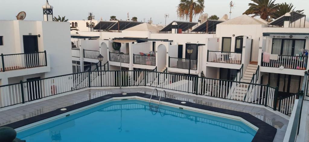 vistas a la piscina desde el balcón de un hotel en Apartamento Lanzarote Volcano, en Puerto del Carmen