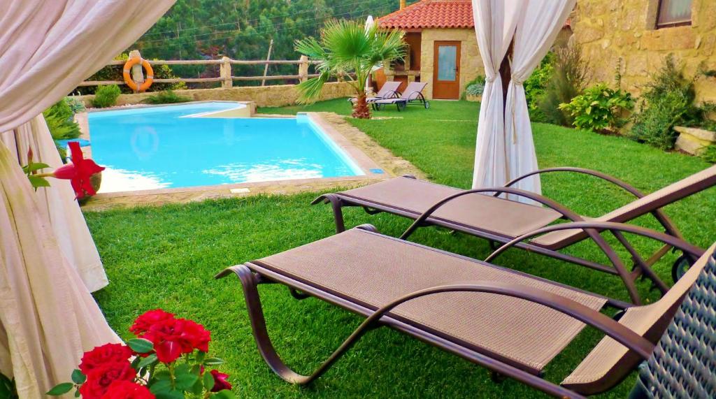 une cour avec deux chaises et une piscine dans l'établissement Love Story - Piscina & Sauna, à Arcos de Valdevez