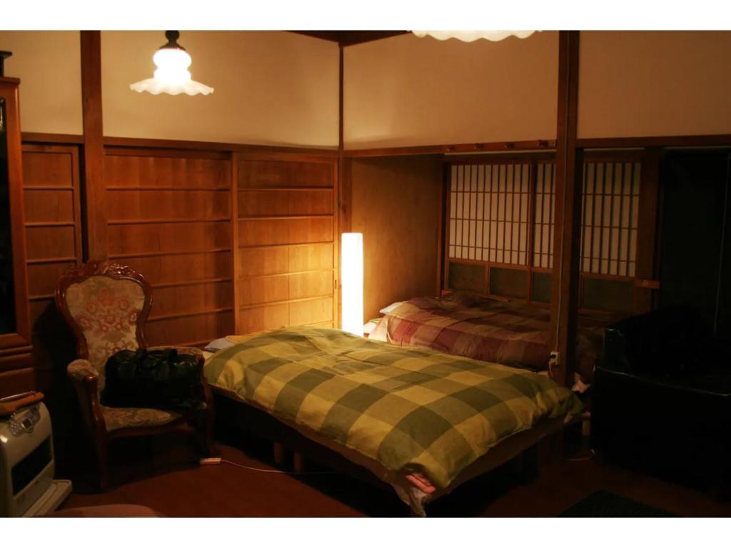 een slaapkamer met een bed en een stoel bij Saraya - Vacation STAY 41728v in Kamiyama