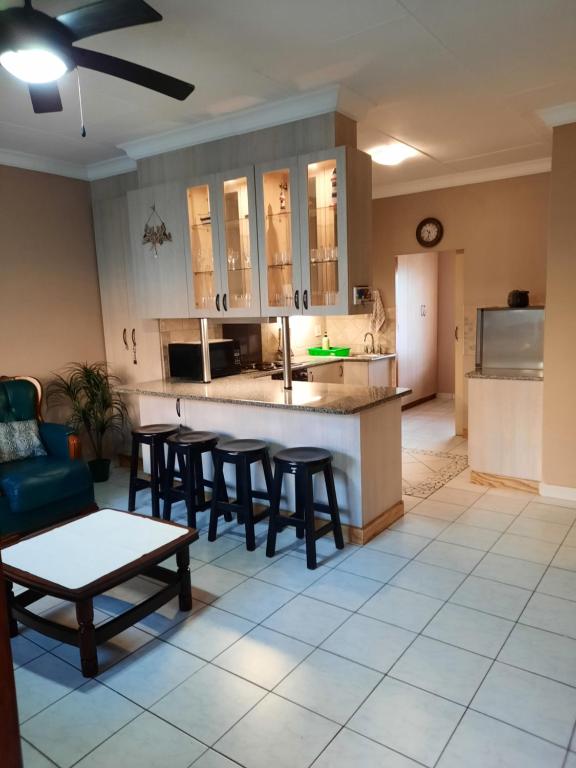 a kitchen and living room with a table and chairs at Uvongo square Unit 24 in Uvongo Beach