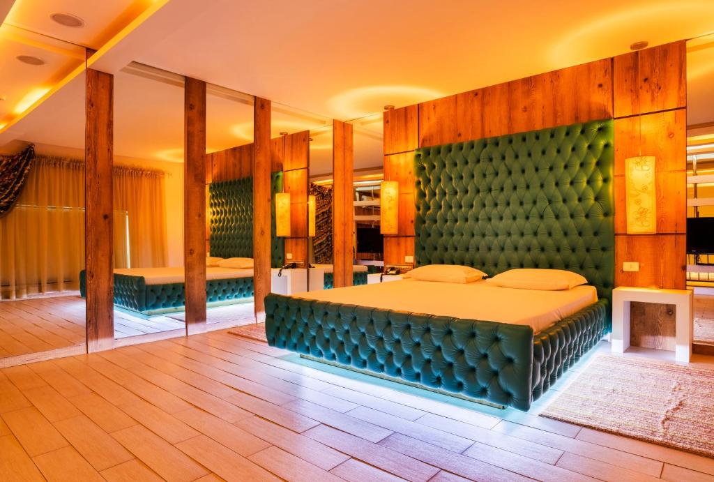 1 dormitorio con 1 cama grande y espejo grande en Gran Motel Dubai, en Caxias do Sul