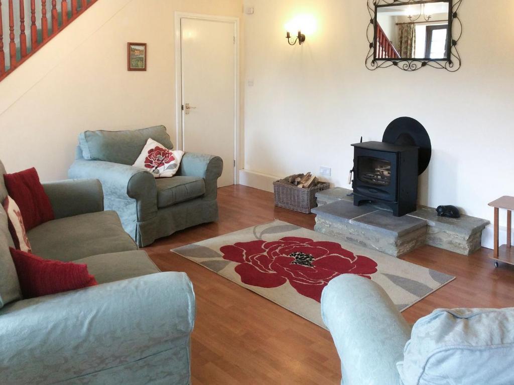 a living room with two couches and a fireplace at The Stables in Alton Pancras