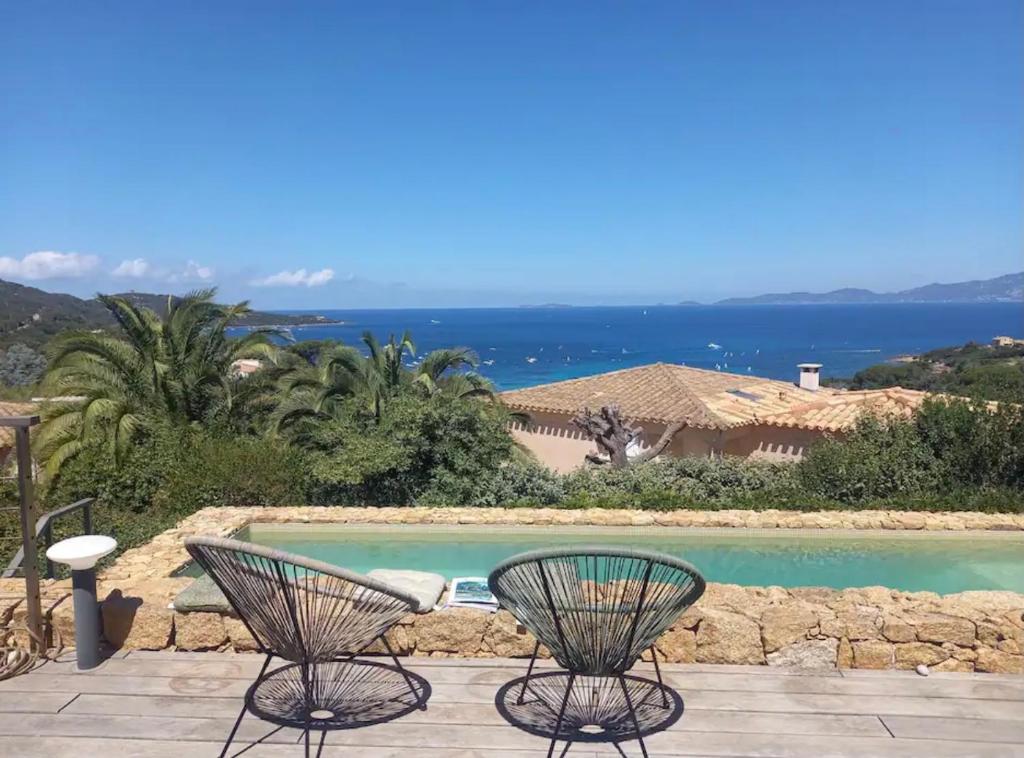 eine Terrasse mit 2 Stühlen und einem Pool in der Unterkunft Magnifique villa vue mer avec piscine in Coti-Chiavari