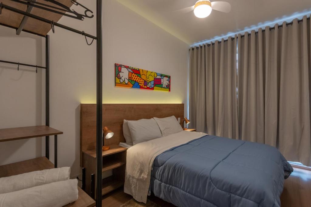 ein Schlafzimmer mit einem blauen Bett und einem Fenster in der Unterkunft Apartamento no Brás com Elevador in São Paulo