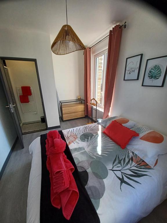 sypialnia z łóżkiem z czerwonymi ręcznikami w obiekcie Nid douillet ernee w mieście Ernée