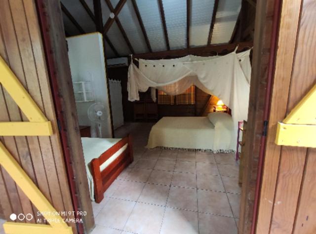 a bedroom with a bed with a canopy at Bakoulélé en Guadeloupe in Bouillante