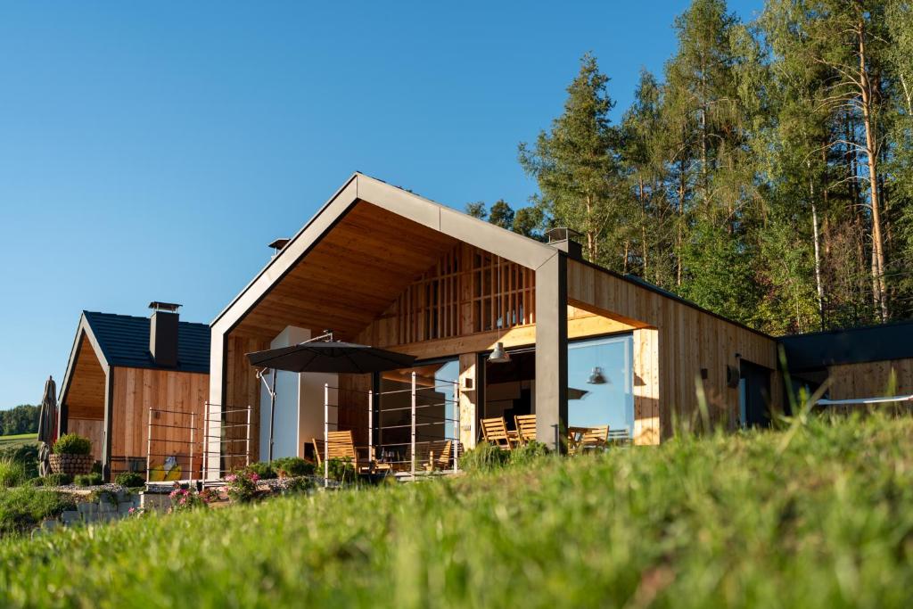 a wooden house with an umbrella in a field at Transmontana in Vols am Schlern