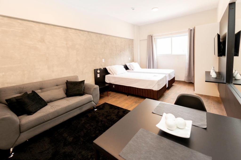 een woonkamer met een bank en een bed bij Tulip Inn Sorocaba in Sorocaba