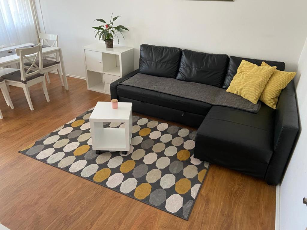 a living room with a black couch and a rug at Apartman Perica in Zagreb