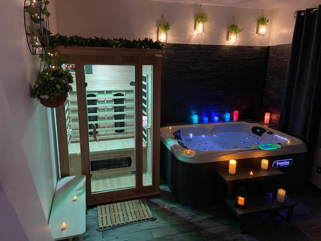 eine Whirlpool-Badewanne in einem Zimmer mit Fenster in der Unterkunft le tricosy jacuzzi et sauna privatif in Tricot