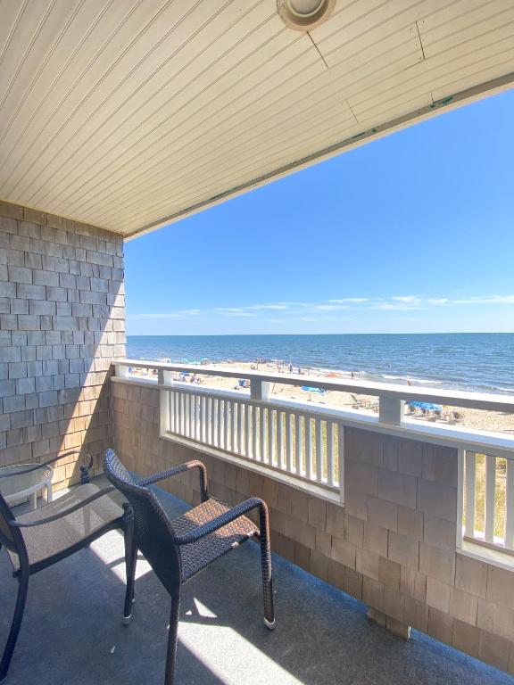 eine Veranda mit Bank und Blick auf den Strand in der Unterkunft Seashell Motel in Dennis