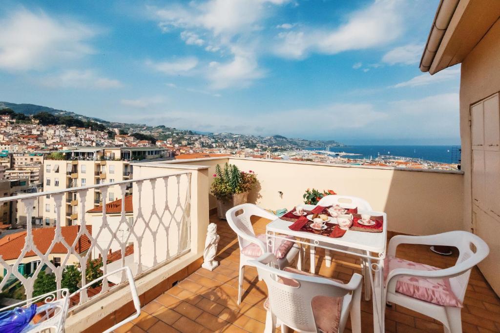 een balkon met een tafel en stoelen en uitzicht op de stad bij Dimora Bellavista,garage privato,due piani in Sanremo