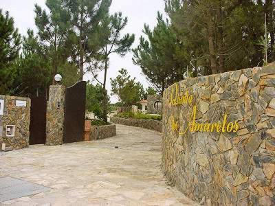 a stone wall with a sign for a zoo at Quinta Dos Amarelos no Meco in Aldeia do Meco