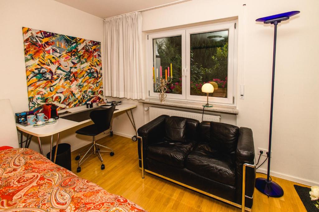 a bedroom with a couch and a desk and a window at Modernes und gemütliches Designerzimmer in Langensteinbach