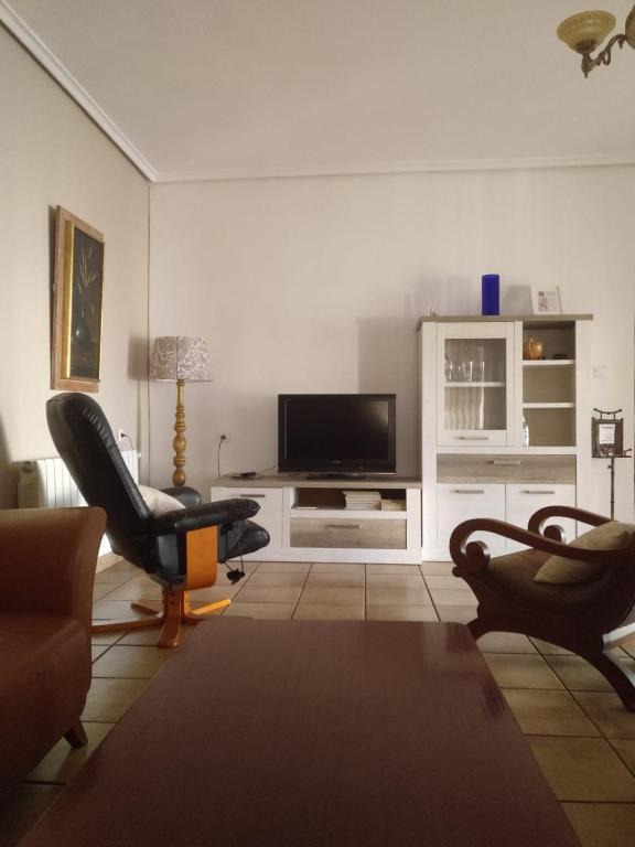 a living room with two chairs and a flat screen tv at Casa Rural POSADA DEL JUCAR in La Gila