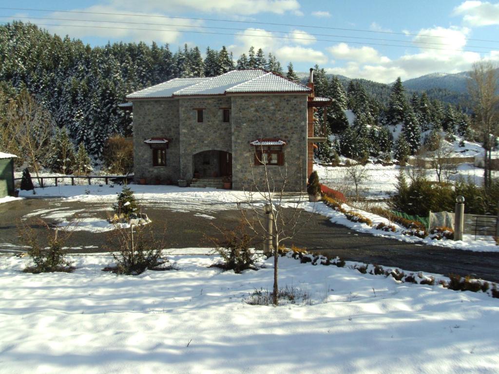 dom w śniegu z przodu w obiekcie Guest House Pantos Kairou w mieście Karkaloú